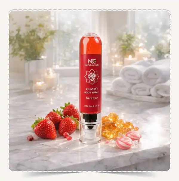 عبوة معطر الجسم يمي Yummy Body Spray Intense مع فراولة طازجة وحلويات وأحجار عنبر على سطح رخامي.