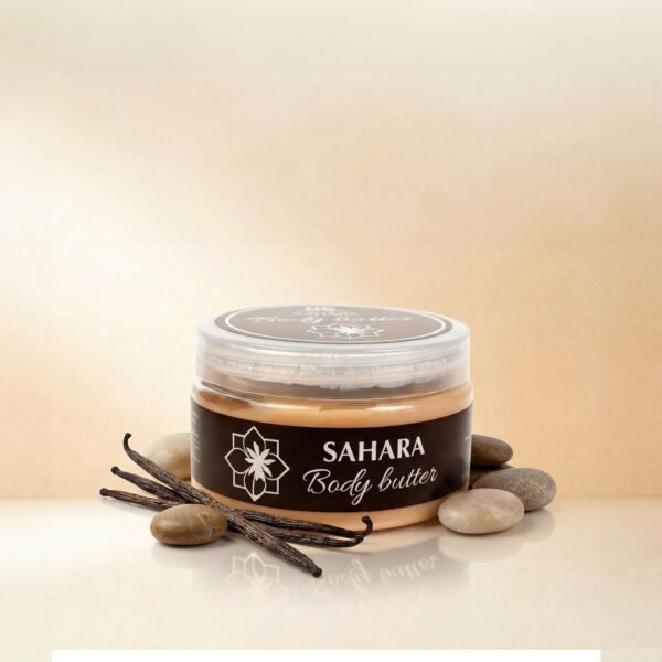 صورة إعلانية تعرض أفضل زبدة الجسم صحارى Body Butter Sahara من ناتشرال كير عمان، تبرز العبوة الدائرية الشفافة بملصقها البني الأنيق محاطة بأعواد الفانيلا الطبيعية وأحجار الصحراء الناعمة على سطح زجاجي عاكس.