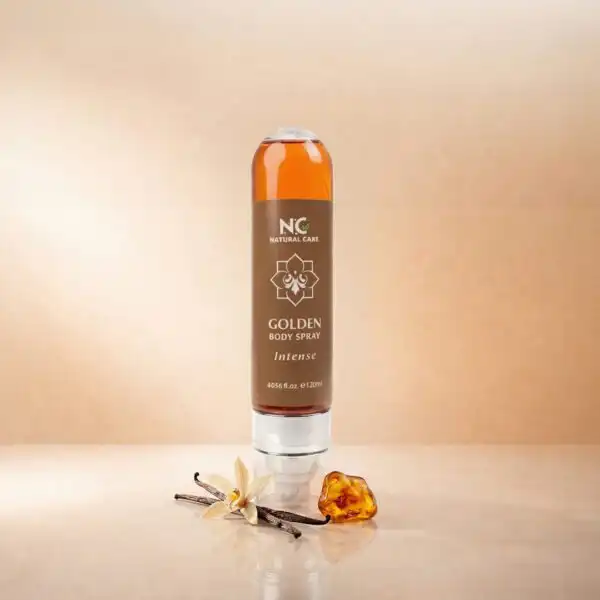 معطر الجسم الذهبي جولدن Golden Body Spray المكثف من ناتشرال كير عمان، عبوة أنيقة تحتوي على سائل عطري بلون الكهرمان، محاطة بزهرة وأعواد الفانيليا الطبيعية وحجر العنبر المضيء لتعكس رائحتها الدافئة والفخمة.