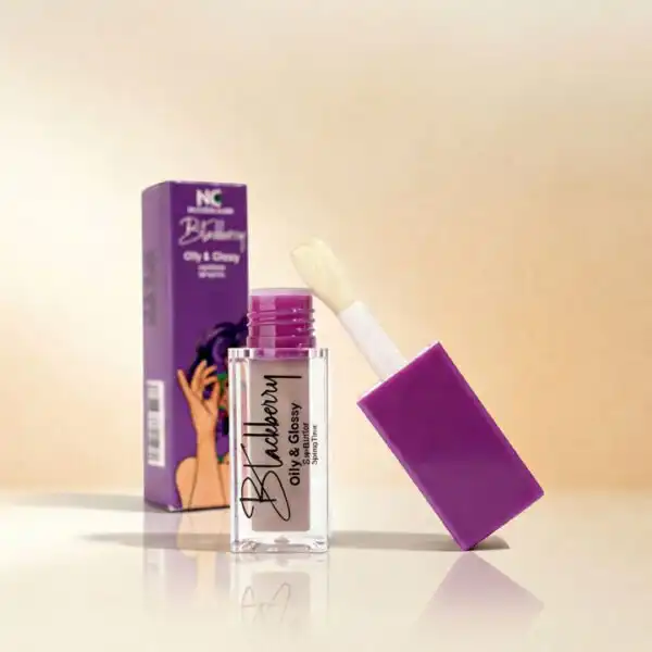 عبوة مفتوحة من جلوس الشفاه بالبلاك بيري Lip gloss - blackberry من ناتشرال كير عمان، تظهر بلمعان زجاجي فائق بجانب الصندوق الأرجواني الأنيق لتعكس الفخامة والترطيب.