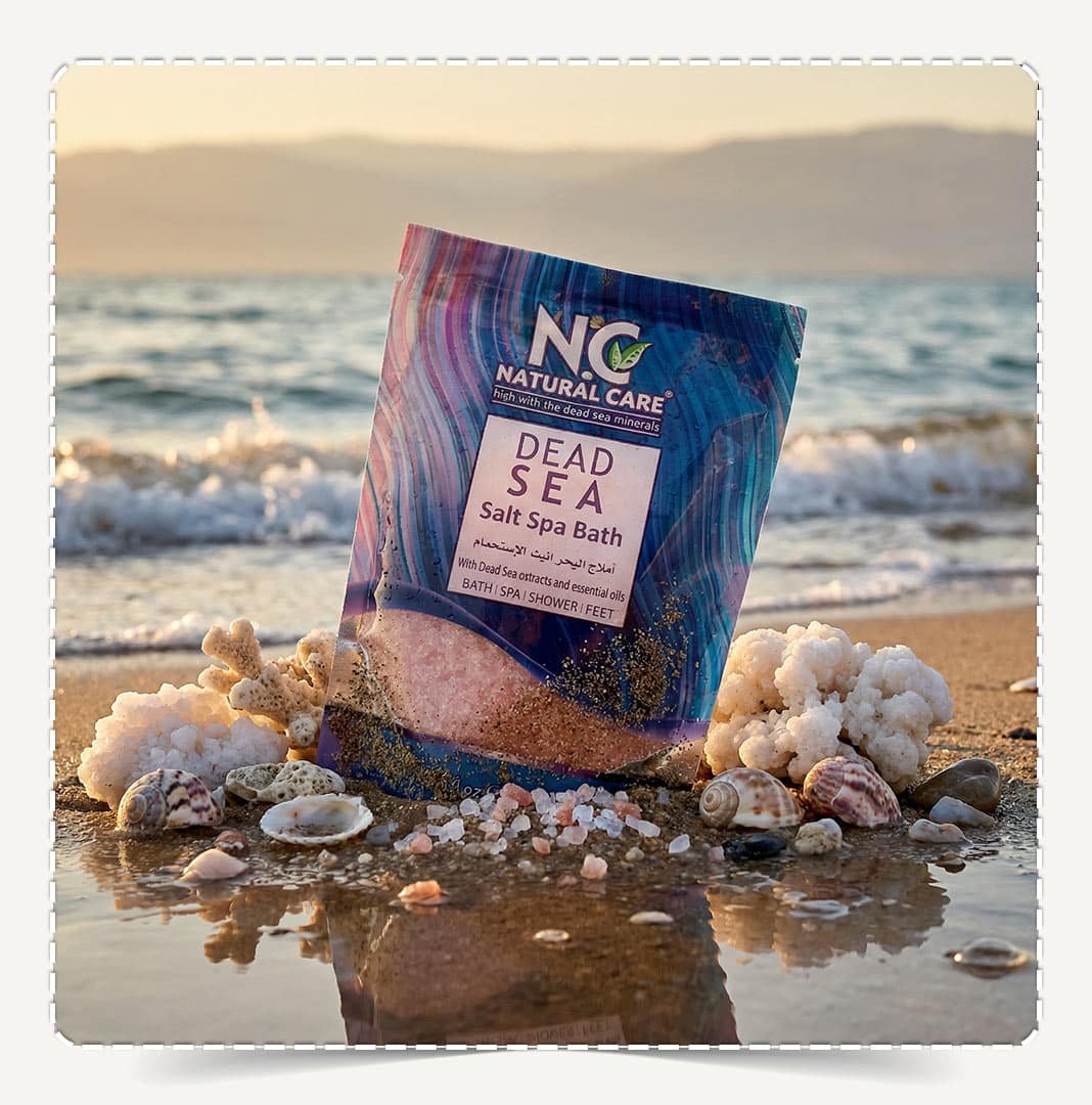 كيس أملاح البحر الميت للاستجمام Dead Sea Salt Spa Bath وزن 250 جم على رمال الشاطئ مع صدف وشعاب مرجانية.