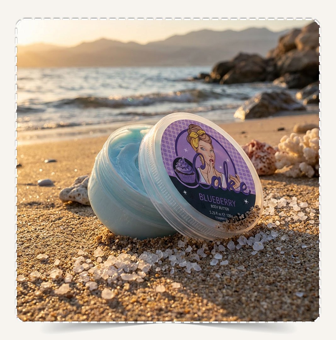 زبدة الجسم بلوبيري Blueberry Natural Body Butter مفتوحة تظهر القوام الأزرق الفاتح على الشاطئ.