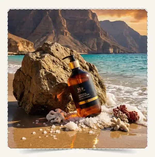 عبوة غسول اليدين بمعادن البحر الميت Dead Sea Mineral Hand Wash بحجم 500 مل على صخرة شاطئية في سلطنة عمان.