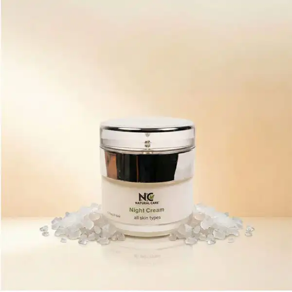 عبوة كريم الليل لتجديد وترطيب البشرة Night Cream من ناتشرال كير عمان، تتوسط بلورات أملاح البحر الميت النقية لتعكس العناية الطبيعية والترطيب العميق أثناء النوم.