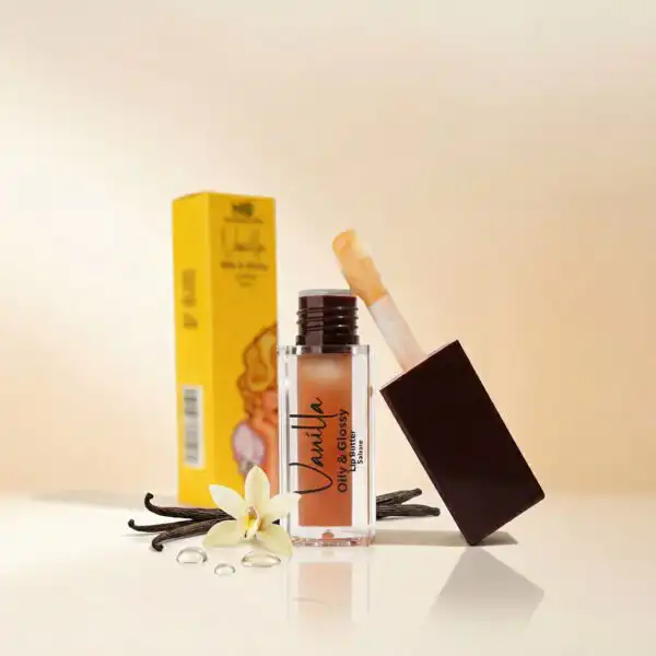 عبوة مفتوحة من جلوس الشفاه بالفانيلا Lip Gloss - Vanilla من ناتشرال كير عمان، بجانب زهرة الفانيليا البيضاء وأعواد الفانيليا الطبيعية لتعكس الترطيب الفائق واللمعان الزجاجي.