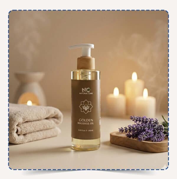 عبوة Golden Massage Oil بنية اللون مع مضخة، محاطة بالشموع والمناشف وزهور اللافندر في أجواء سبا هادئة – ناتشورال كير عمان