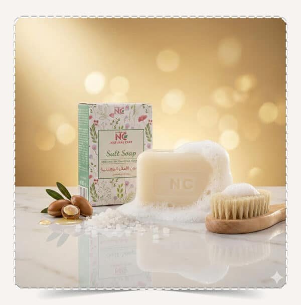 صابون الأملاح المعدنية بمعادن البحر الميت | Salt Soap مع العبوة والقطعة على سطح لامع وخلفية ذهبية، Natural Care Oman ناتشورال كير عمان