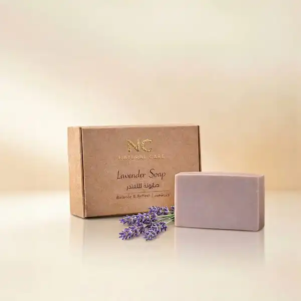 صندوق وقطعة صابونة اللافندر الطبيعية - Lavender Soap من ناتشرال كير عمان، مزينة بأعواد زهور اللافندر البنفسجية الطازجة لتعكس النقاء والهدوء والاسترخاء.