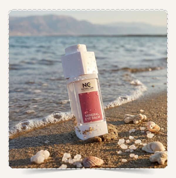 كريم العين المعدني | Mineral Eye Balm من Natural Care Oman | ناتشورال كير عمان — عبوة على شاطئ البحر مع أملاح ورمال