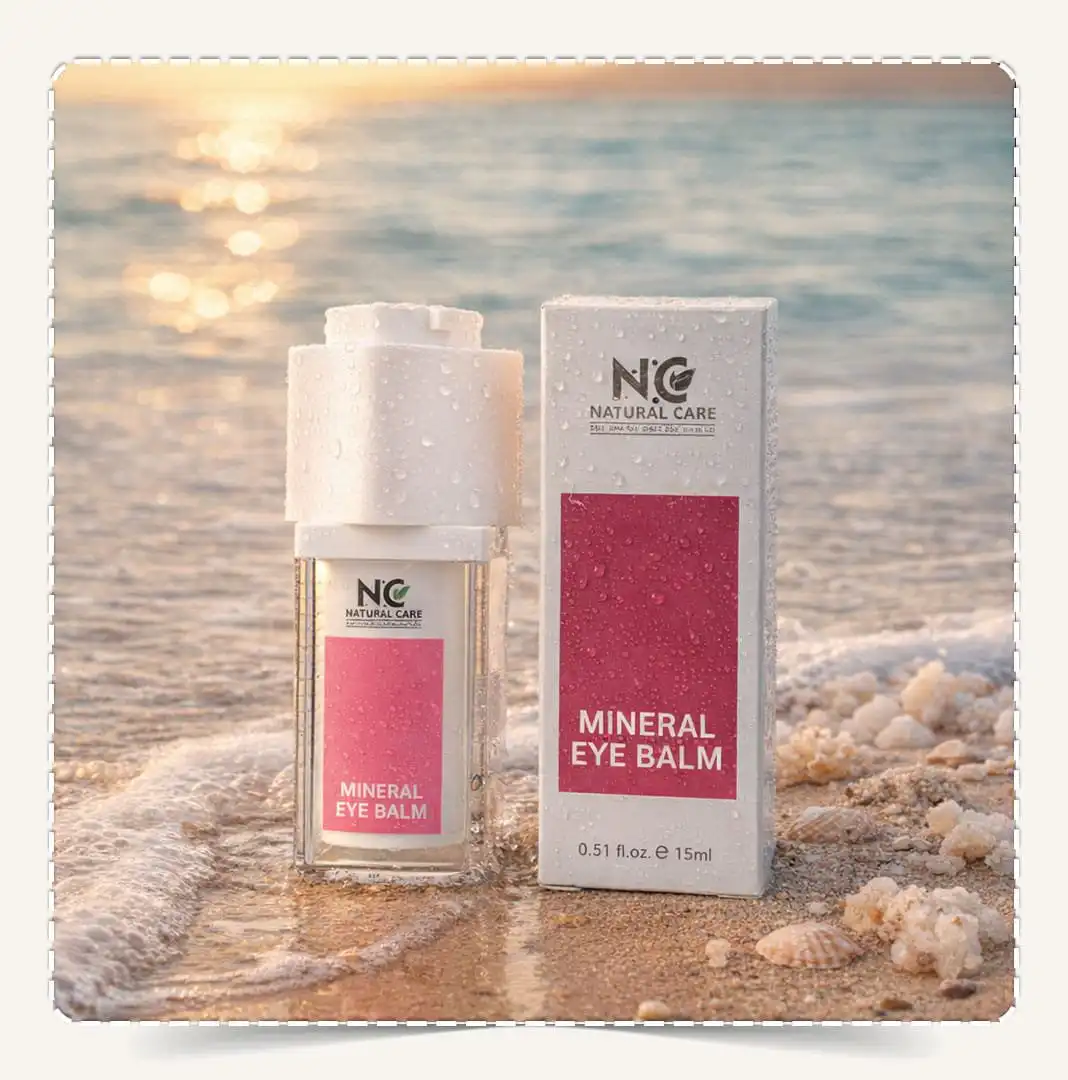 كريم العين المعدني | Mineral Eye Balm من Natural Care Oman | ناتشورال كير عمان — العبوة مع علبة المنتج على الشاطئ