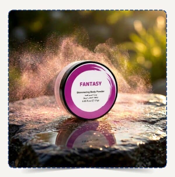 علبة Fantasy Body Powder دائرية بلمسات بنفسجية وسط تناثر ذرات البودرة اللامعة الوردية والبنفسجية تحت الإضاءة