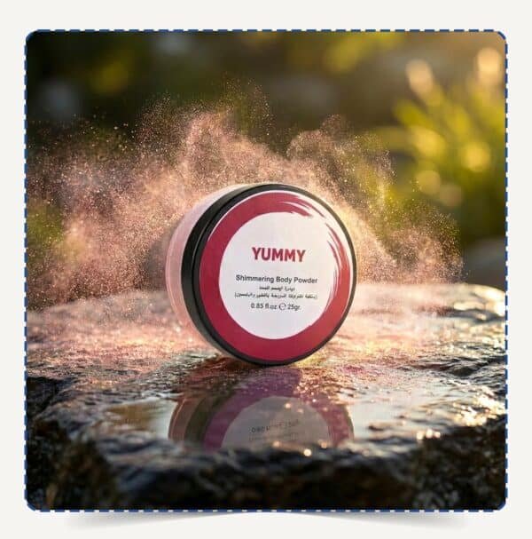 علبة Yummy Body Powder دائرية وسط تناثر ذرات البودرة اللامعة تحت أشعة الشمس الذهبية