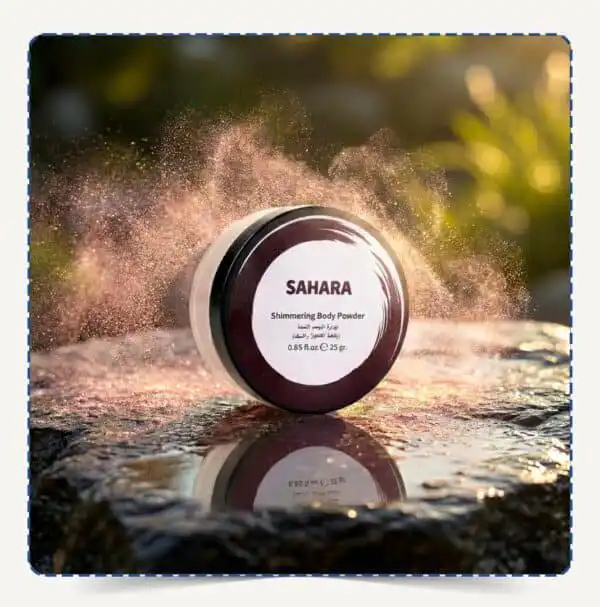 علبة Sahara Body Powder دائرية بلمسات بنية وسط تناثر ذرات البودرة اللامعة البرونزية تحت الإضاءة