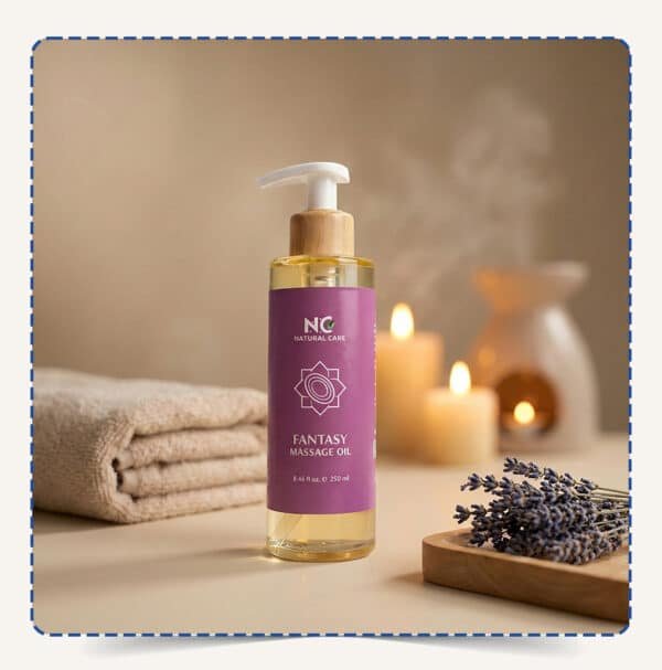 عبوة Fantasy Massage Oil بتصميم بنفسجي ساحر مع مضخة خشبية، محاطة بالمناشف والشموع وزهور اللافندر في أجواء سبا هادئة – ناتشورال كير عمان