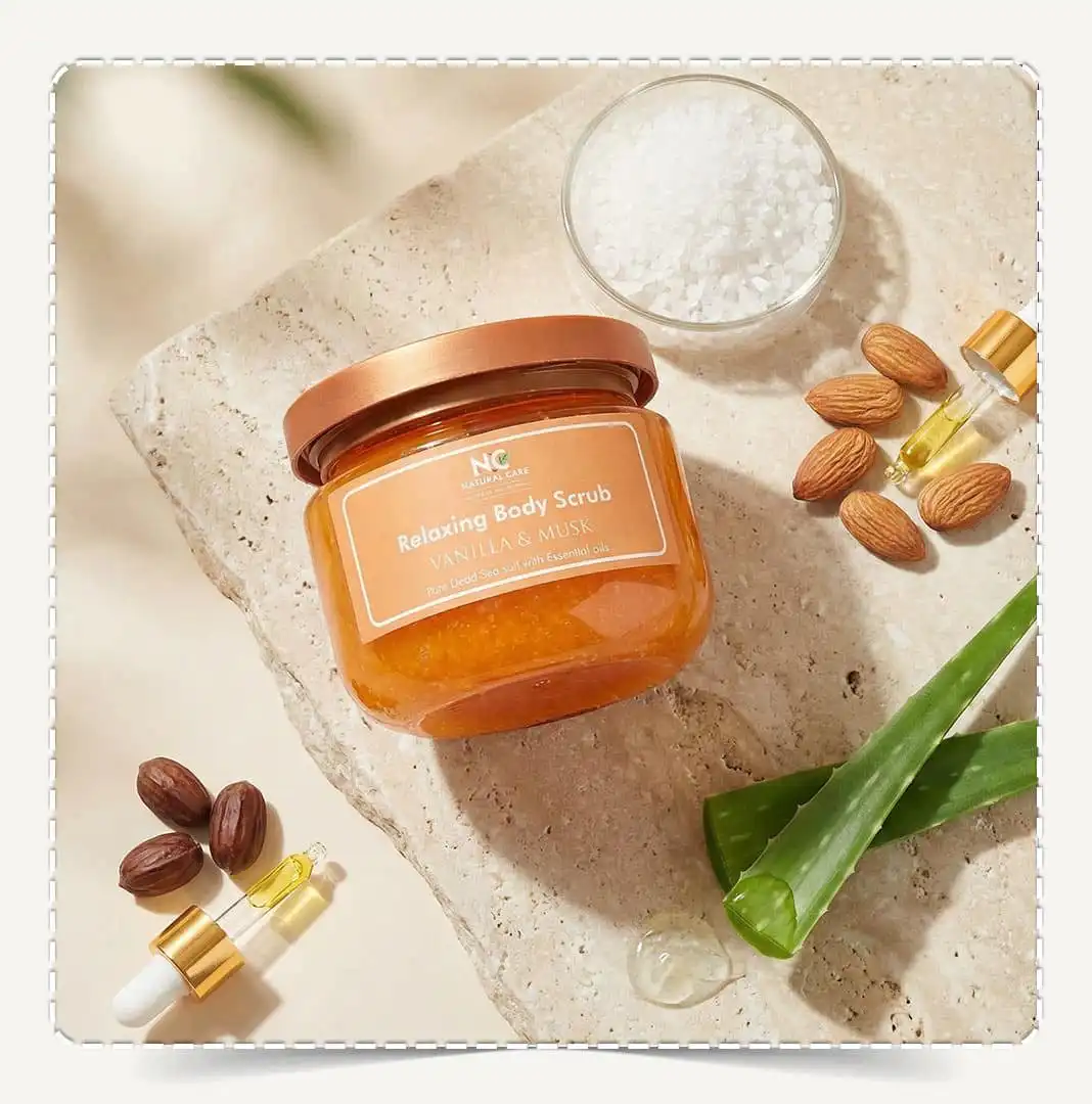 تصوير علوي لمنتج مقشر جسم طبيعي بزيت الفانيليا والمسك Natural Body Scrub Vanilla & Musk مع حبات اللوز وورقة الصبار وزيت مغذي.
