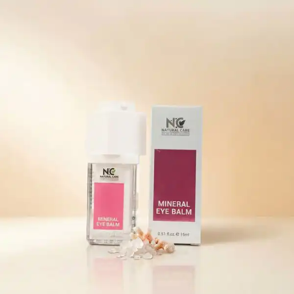 عبوة وزجاجة كريم العين المعدني | Mineral Eye Balm من ناتشرال كير عمان، موضوعة بجوار بلورات أملاح البحر الميت وقطع مرجانية لتعكس الترطيب المعدني والنضارة.