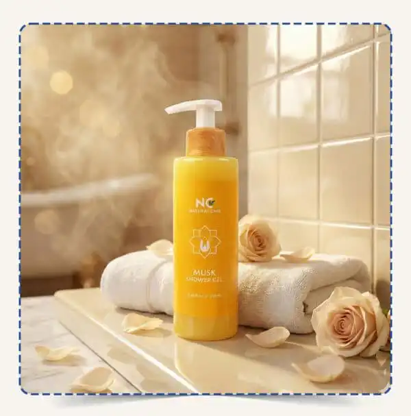 زجاجة Musk Shower Gel | شاور جيل المسك مع منشفة بيضاء وورد كريمي بإضاءة دافئة – Natural Care Oman
