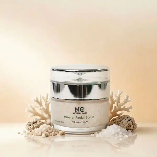 عبوة مقشر الوجه المعدني لتنقية ونضارة البشرة Mineral Facial Scrub من ناتشرال كير عمان، محاطة بقطع المرجان الأبيض وأملاح البحر الميت الطبيعية لتقشير لطيف وفعال.