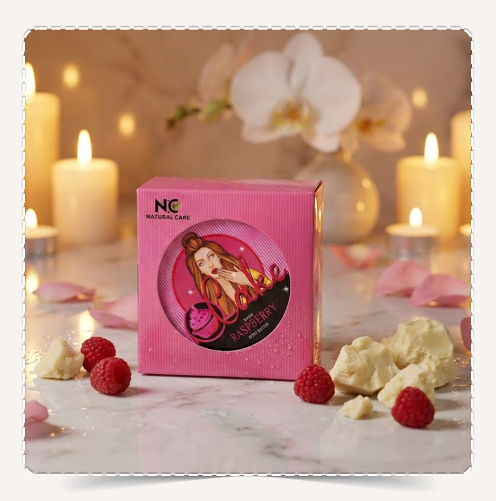 علبة زبدة الجسم الطبيعية راسبيري Raspberry Natural الوردية وسط الشموع وقطع زبدة الشيا وحبات التوت في أجواء سبا رومانسية.