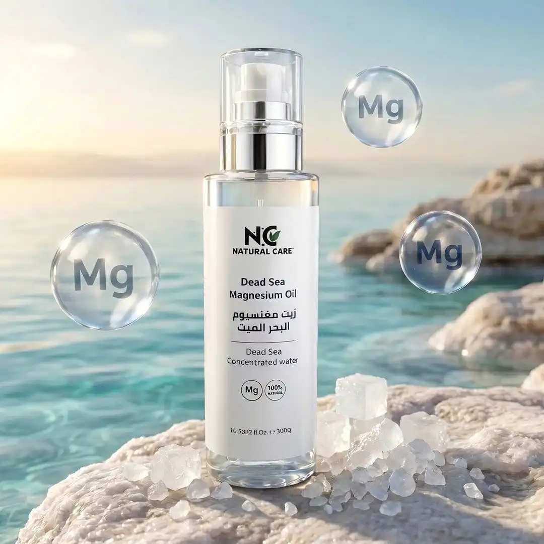 أفضل Magnesium Oil طبيعي من ناتشرال كير عمان، عبوة زيت مغنيسيوم البحر الميت النقي تستقر على صخور ملحية بيضاء أمام مياه البحر الفيروزية، محاطة بفقاعات طافية تحمل رمز (Mg).