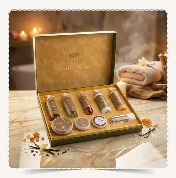 صندوق مجموعة جولدن | Golden Collection المفتوح بعبواته الفاخرة على رخام أبيض في أجواء سبا دافئة مع أعواد الفانيليا وأملاح البحر.